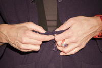 Aufknöpfen einer Jacke - das besondere Zusammenspiel der Finger wird deutlich